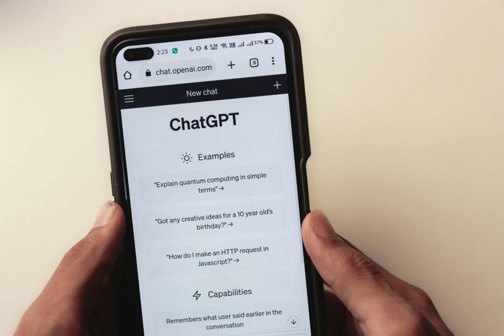 Close up of hands holding a smartphone displaying the chatgpt application interface on the screen.